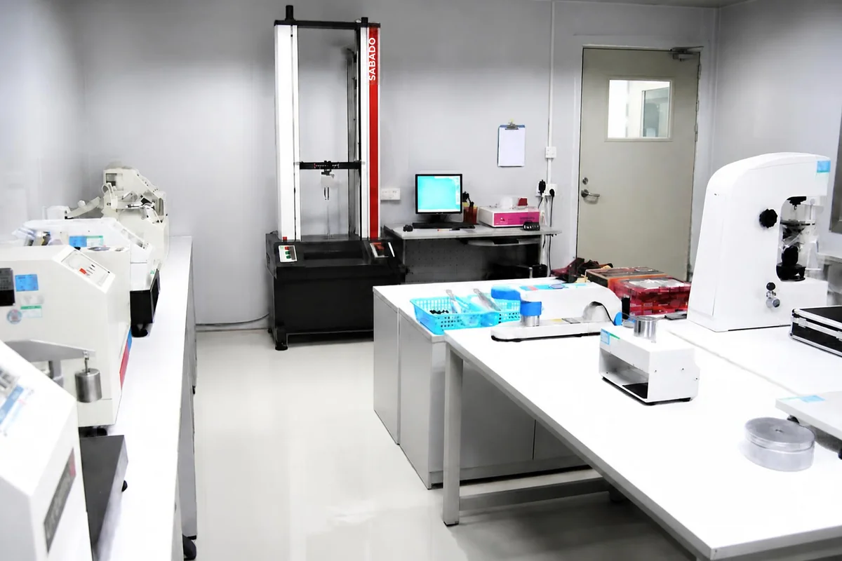 In-house testing laboratory at the woven vinyl production base in Zhejiang: benches of physical testing equipment, a tensile strength tester and a test workstation