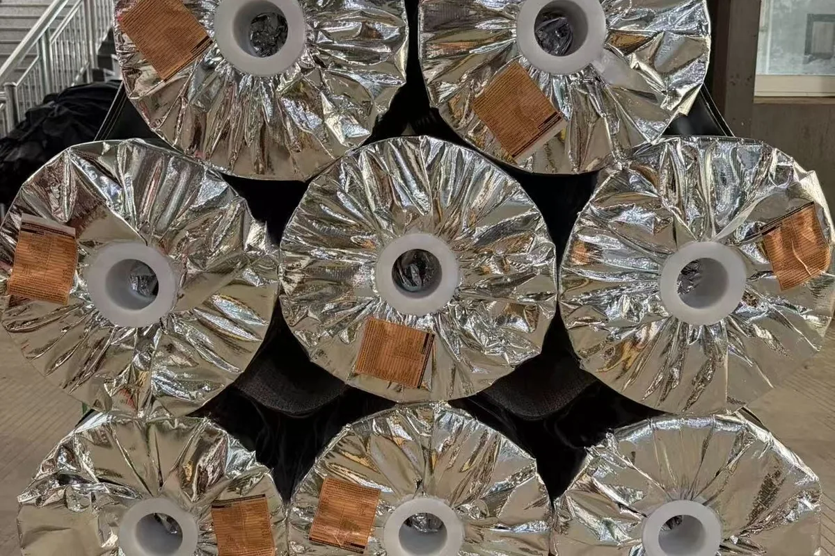 Wall to wall rolls foil-wrapped and stacked on a pallet in the warehouse at the woven vinyl production base in Zhejiang