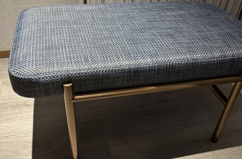 Woven vinyl upholstery on a hotel bench in a blue-silver 4x4 weave, on timber legs
